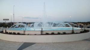 a fountain in a parking lot with two fountains at Casa Casella, delizioso bilocale a due passi dal mare in Lido di Ostia