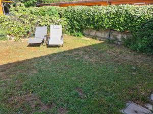 zwei Gartenstühle auf dem Rasen im Garten in der Unterkunft Ostia Antica Urlaub mal anders in Ostia Antica