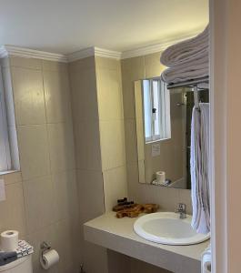 a bathroom with a sink and a mirror at Hotel Afrika in Eleonas +20 photos