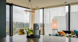 sala de estar con sofá y ventana grande en Penthouse La Naturale zeezicht en Zeebrugge