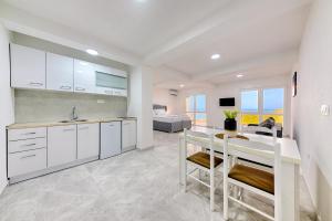 a kitchen with white cabinets and a sink at Apartmani Panorama in Bar
