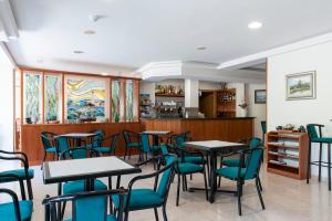 a restaurant with tables and chairs and a counter at Hotel Cabo Festiñanza in Sanxenxo