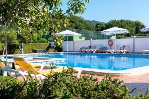 a large swimming pool with chairs and umbrellas at Hotel Cabo Festiñanza in Sanxenxo