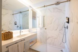 a bathroom with a shower, sink, and mirror at Tempo FLH Hotels Lisboa in Lisbon