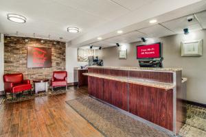 eine Lobby mit einer Bar mit roten Stühlen und einem TV in der Unterkunft Red Roof Inn Columbia East - Ft Jackson in Columbia