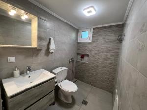 a bathroom with a white toilet and a sink at Gazena House in Sívros