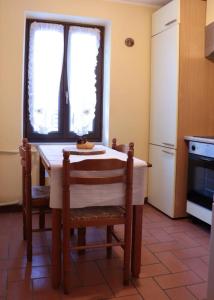 a kitchen with a table and chairs and a kitchen with a window at Petit-Antey 38 in Antey-Saint-André