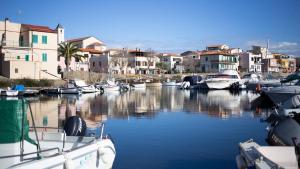 a group of boats docked in a river with buildings at casetta sul porticciolo in Stintino