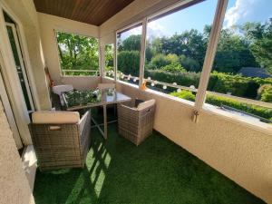 a balcony with a table and chairs and windows at Duplex à 2 pas de l'aéroport, proche ONU & Palexpo in Ferney-Voltaire