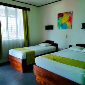 1 Schlafzimmer mit 2 Betten und einem Fenster in der Unterkunft San Bosco Inn in Fortuna