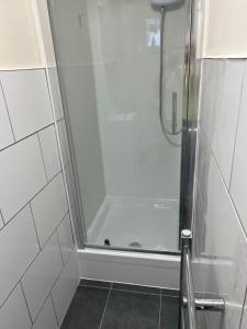 a shower with a glass door in a bathroom at North West Lodge Guest House in London +44 photos