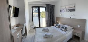 a bedroom with a large bed with a large window at Sun&Sea in Jastarnia
