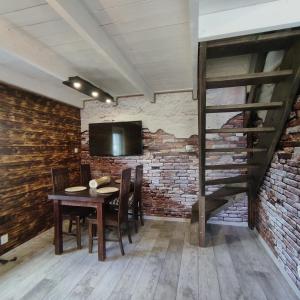 a dining room with a wooden table and a brick wall at Domek pod Karpaczem in Miłków