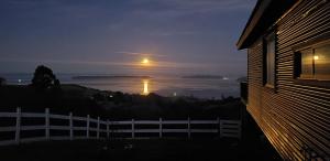 Cette maison offre une vue sur l'océan la nuit. dans l'établissement Cabaña Quiquel, Dalcahue, Chiloe, à Dalcahue