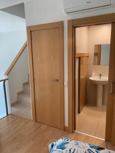 łazienka z drzwiami, umywalką i schodami w obiekcie Loft luminoso Alcorcón M-40 Madrid w mieście Alcorcón