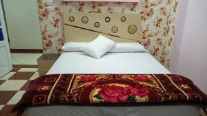 a bedroom with a bed with a floral blanket on it at شقة فندقية اسكندر ابراهيم in Alexandria