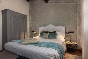 a bedroom with a large white bed with blue pillows at DormiVeglia B&B in Monte San Savino