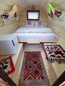 a small room with a bed and two rugs at Cabana Ocna Mesaros in Ocna Şugatag