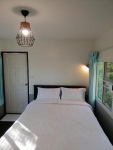帕府的住宿－Sameikei Homestay，卧室设有一张白色大床和一扇窗户。