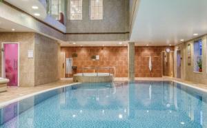 a large swimming pool with a tub in a building at The Hidden Gem in Kegworth