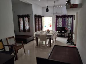 a dining room and living room with a table and chairs at Takashi Homestay North Paravur Near Muziris in North Paravur
