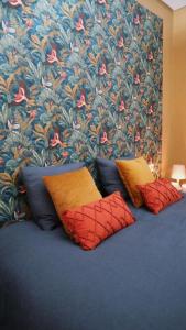 4 almohadas en una cama con pared de flores en Oasis de Bornos, en Bornos