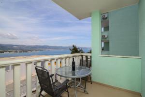 een balkon met een tafel en stoelen en uitzicht op de oceaan bij Apartman Karla in Trogir