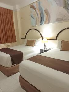 Een bed of bedden in een kamer bij HOTEL VILLA MARGARITAS