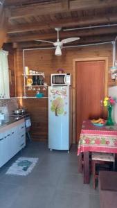 Il comprend une cuisine avec un réfrigérateur et une table. dans l'établissement Tiny House moçambique - Sua casinha em Floripa!, à Florianópolis