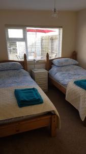 a bedroom with two twin beds and a window at The Annex in Skegness