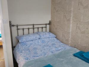 a bedroom with a bed with a blue comforter at The Annex in Skegness