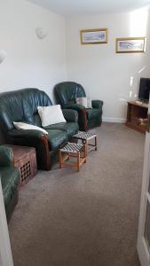 a living room with two green couches and a table at The Annex in Skegness