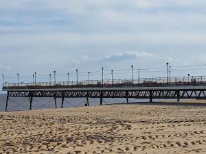 a pier on the beach with people walking on it at The Annex in Skegness