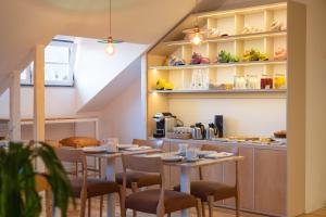a dining room with tables and chairs and a kitchen at Tempo FLH Hotels Lisboa in Lisbon