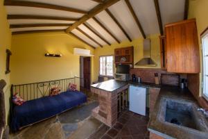 a kitchen with yellow walls and a stone fireplace at Monte Da Coelha AL in Redondo