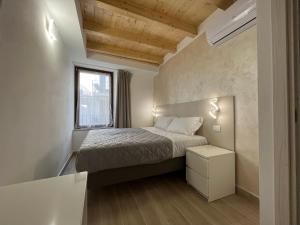 mała sypialnia z łóżkiem i oknem w obiekcie Anfite Apartments Santa Maria w mieście Desenzano del Garda