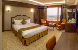 Habitación de hotel con cama y sala de estar. en Al-Borg Hotel, en Jazan