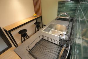 una cucina con lavandino e bancone con sgabelli di Bonanza Apartments a Niš