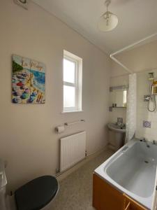a bathroom with a bath tub and a sink at Buckingham Lodge Guest House in Torquay