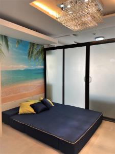1 dormitorio con 1 cama y una pintura de la playa en Honey's Elysees Condotel - Davao en Dávao