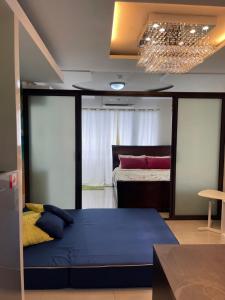 a bedroom with a large blue bed in a room at Honey's Elysees Condotel - Davao in Davao City
