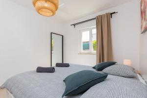 a bedroom with a bed with pillows and a window at House Anna in Poreč