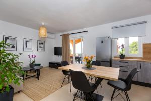 una cucina e un soggiorno con tavolo e sedie di House Anna a Poreč (Parenzo)