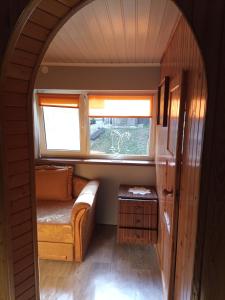 ゴウダプにあるDomek Letniskowyのソファと窓が備わる小さな客室です。