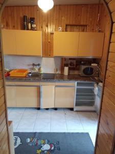 a small kitchen with yellow cabinets and a sink at Domek Letniskowy in Gołdap