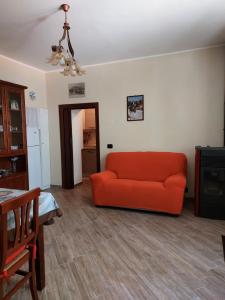 uma sala de estar com um sofá laranja e uma mesa em Zia Elisa em Scanno