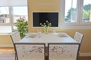 een eettafel met stoelen en een tv bij Apartamento Marejada - Para amantes de la luz y las casas acogedoras in San Vicente de la Barquera