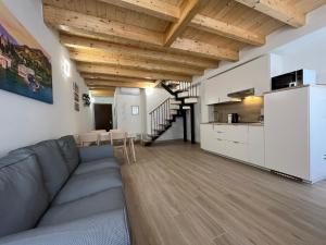 duży salon z kanapą i kuchnią w obiekcie Anfite Apartments Santa Maria w mieście Desenzano del Garda
