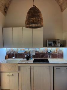 una cucina con lavandino e soffitto di Ca'SaLentu - La Corte dei Colori a Spongano