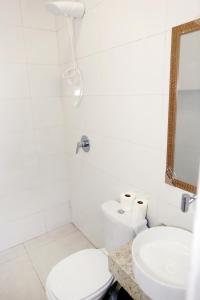 a white bathroom with a toilet and a sink at HOTEL CAPITAL PALMAS in Palmas